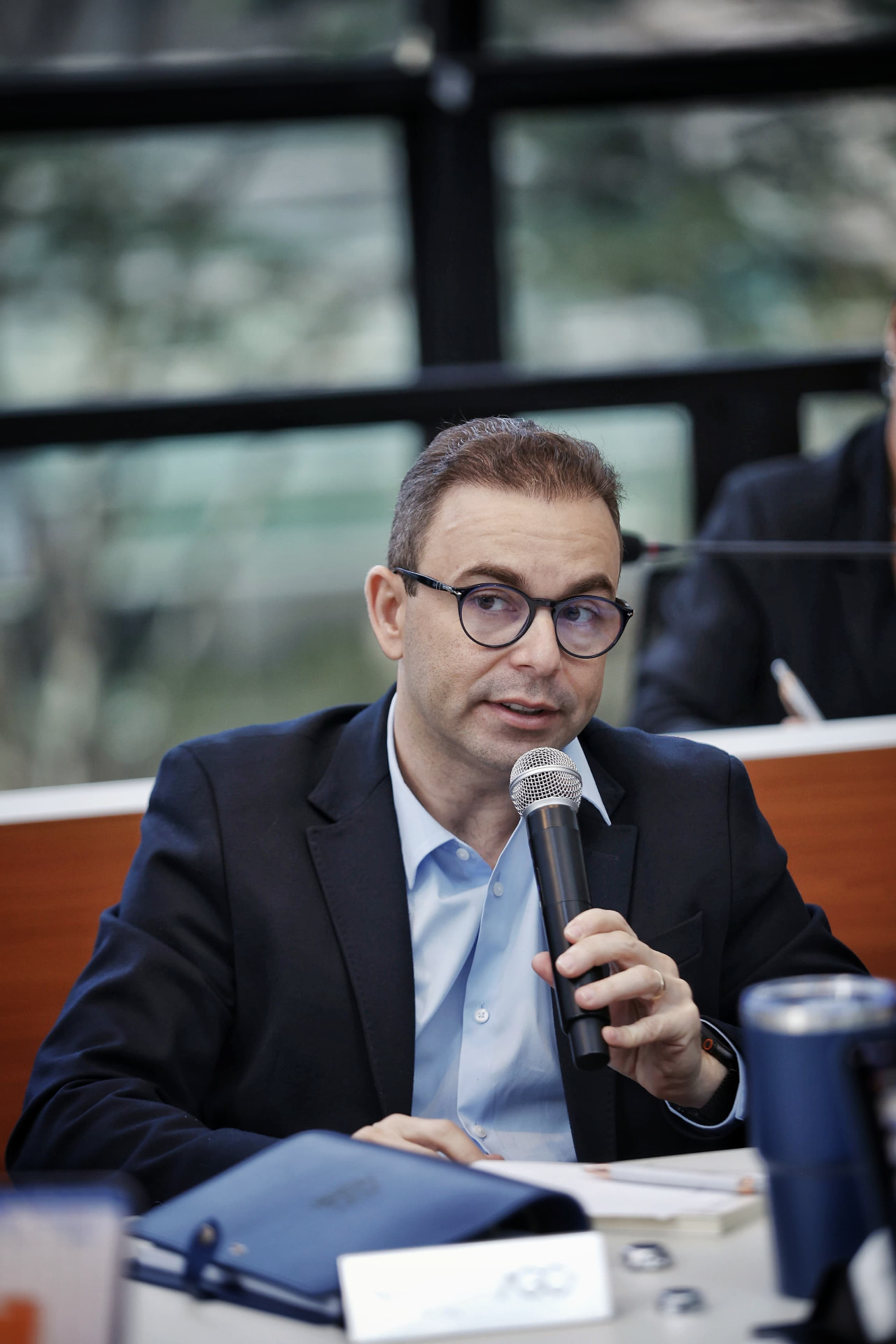 Rogério Hermínio da Silva falando ao microfone em painel executivo